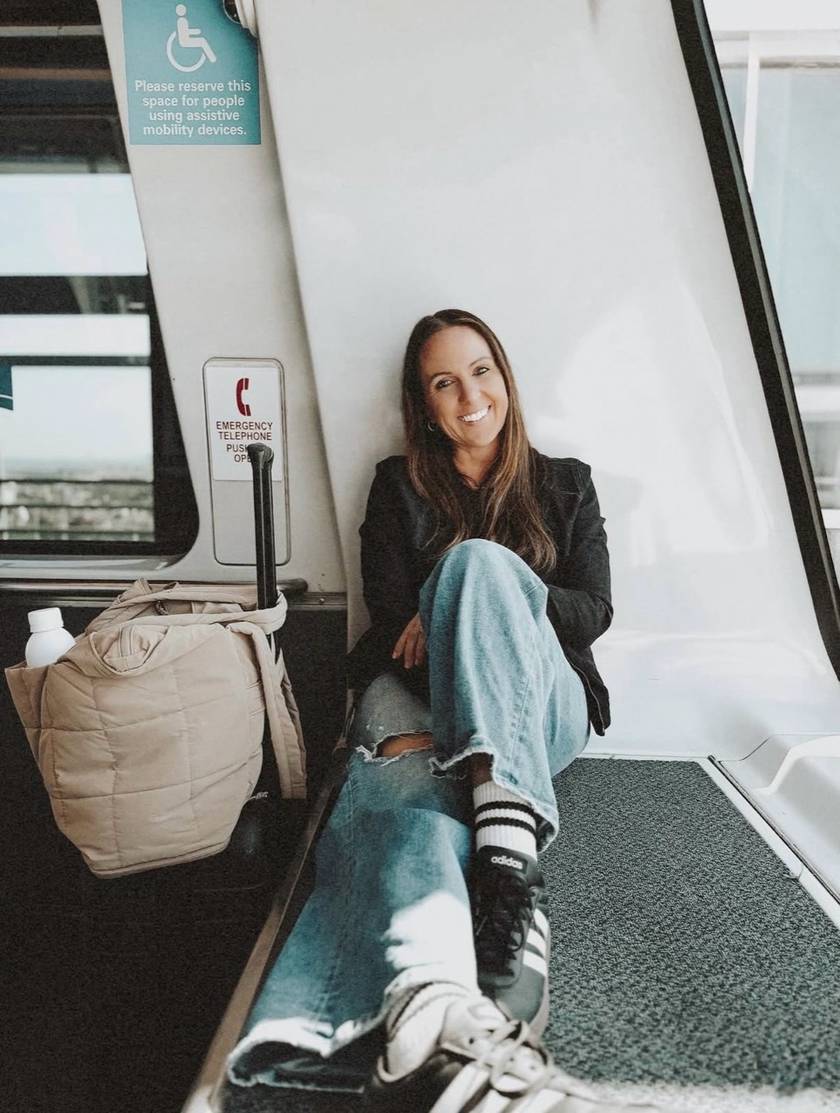 Corrie smiling while seated inside a light rail car